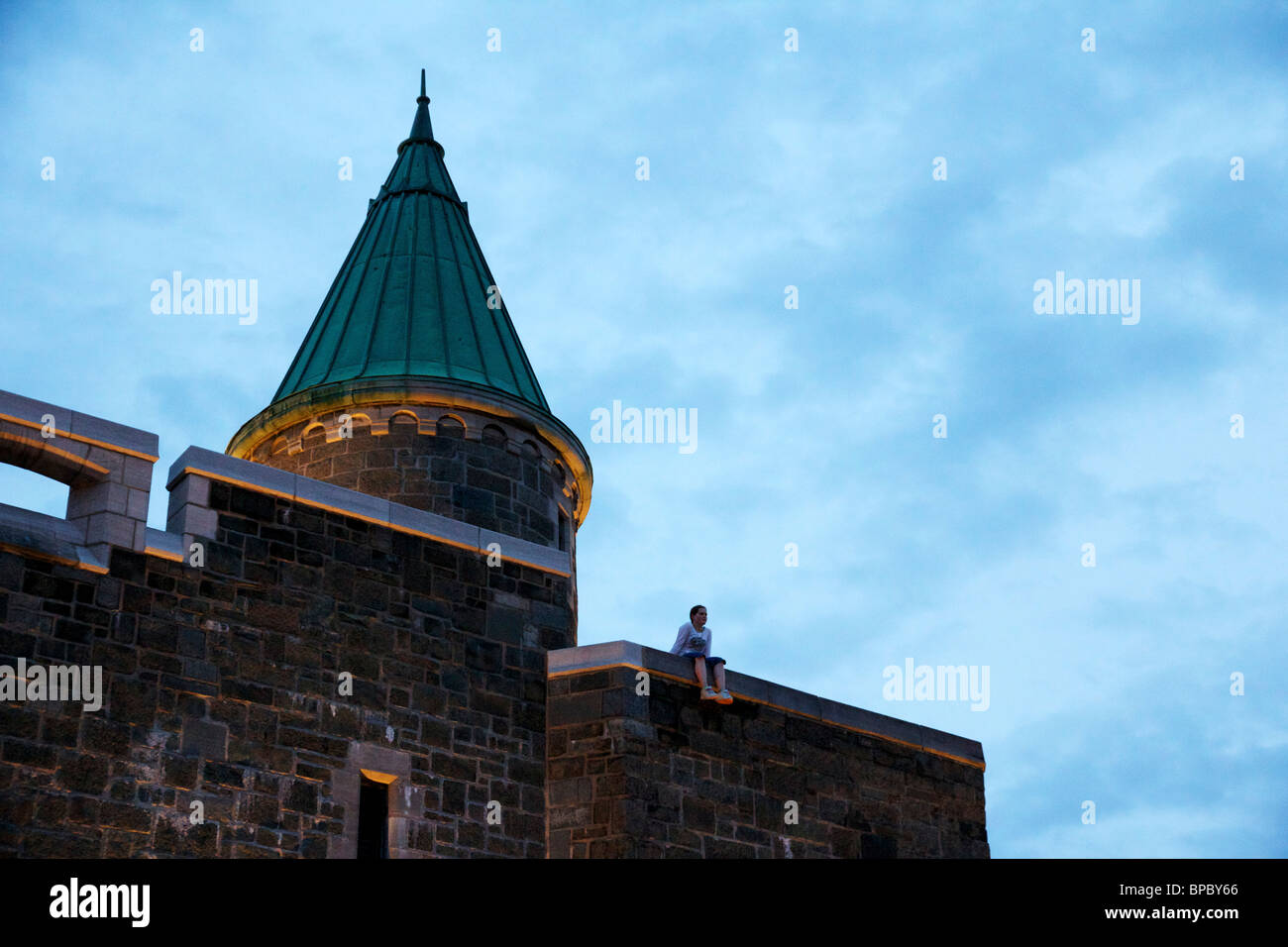 Giovane ragazza seduta sulla parete della città. Vecchia Quebec City, in Canada. Foto Stock