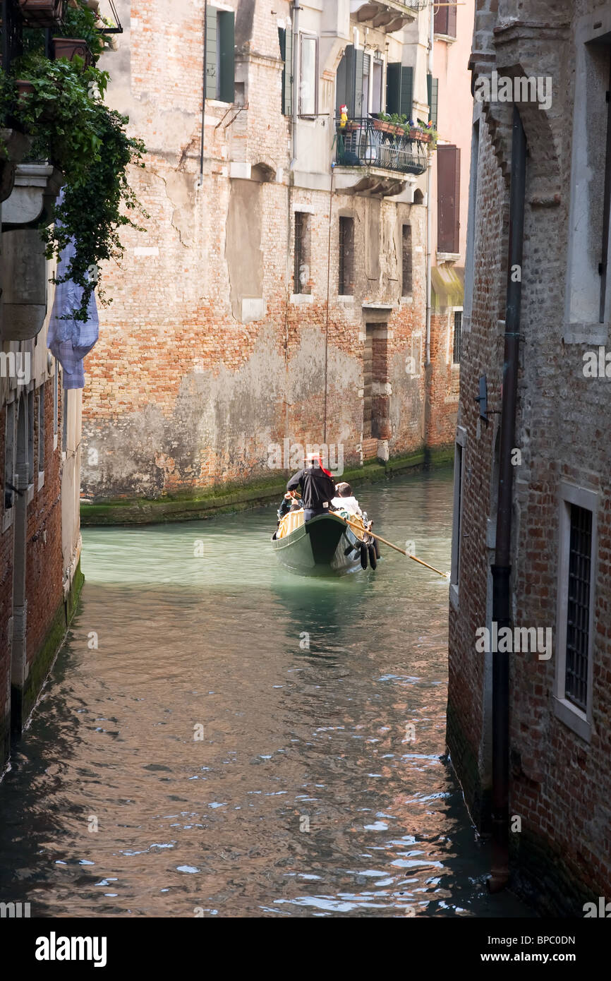 Gondoliere con turisti su un canale in mattinata a Venezia, Italia. Foto Stock