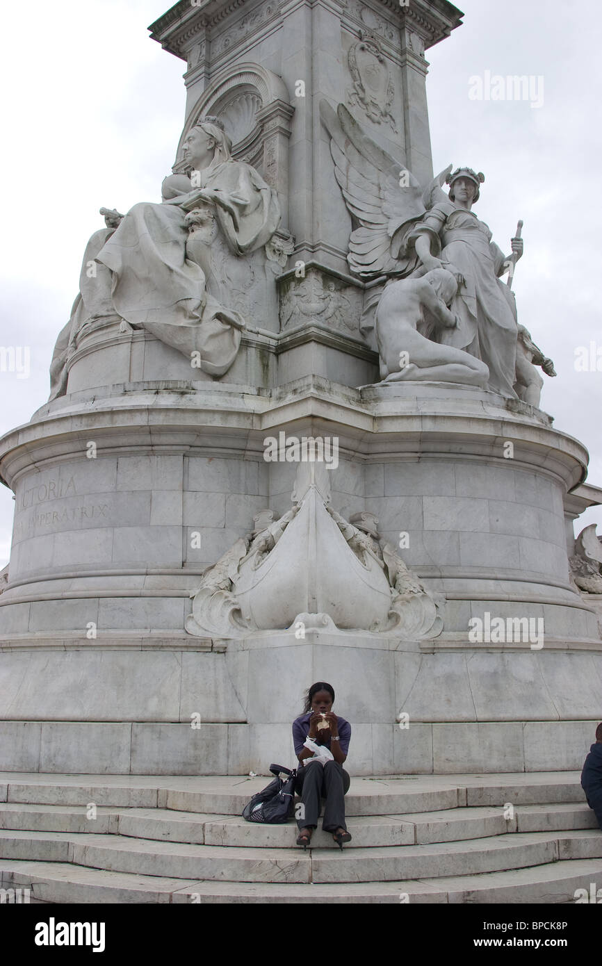 Tourist Queen Victoria statua nero donna mangiare Foto Stock