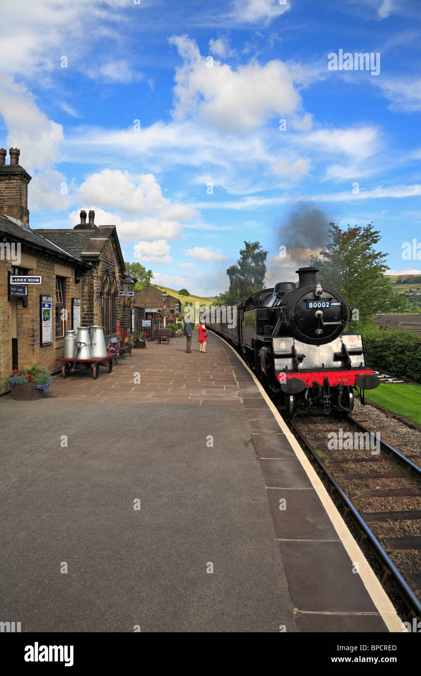 Treno a vapore che arrivano a Oakworth stazione ferroviaria, Keighley e Worth Valley Railway, West Yorkshire, Inghilterra, Regno Unito. Foto Stock