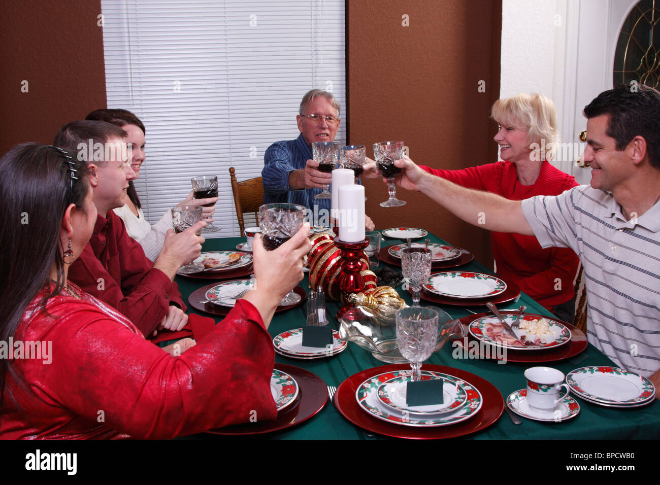 Famiglia la tostatura in cena di Natale Foto Stock