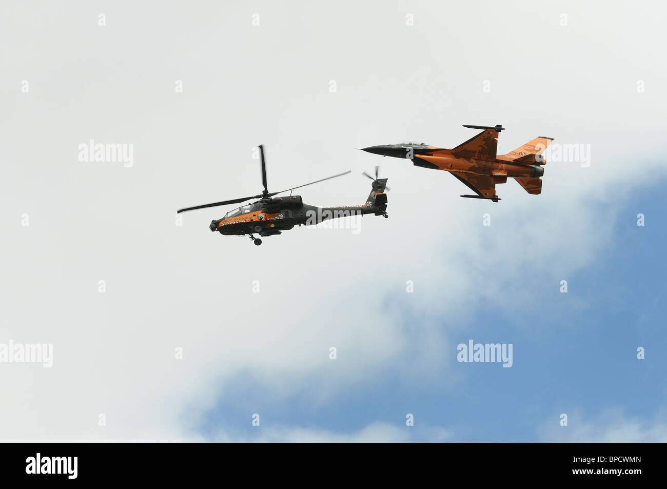 Royal Netherlands Air Force Boeing AH-64D attacco Apache elicottero e General Dynamics F-16 volare in formazione Foto Stock