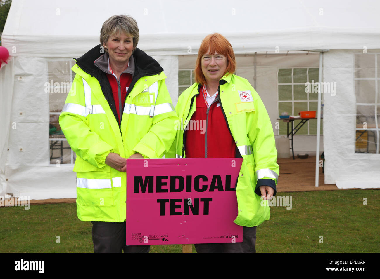 I volontari della Croce rossa a nastro rosa a piedi Bleinham tenda medica Foto Stock
