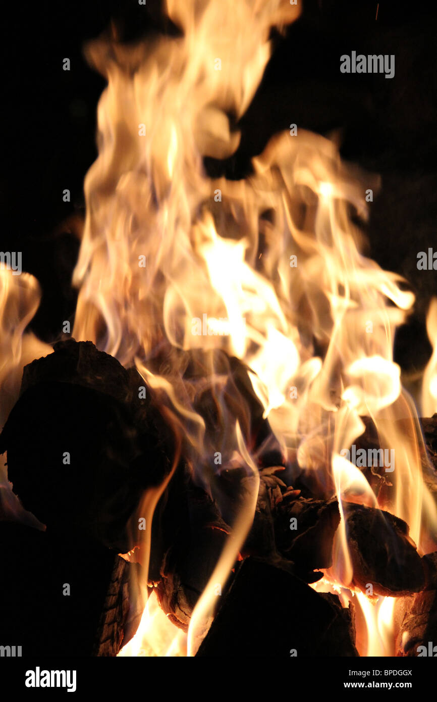 Il fuoco di legna di notte in una buca per il fuoco e fiamme di grandi dimensioni Foto Stock