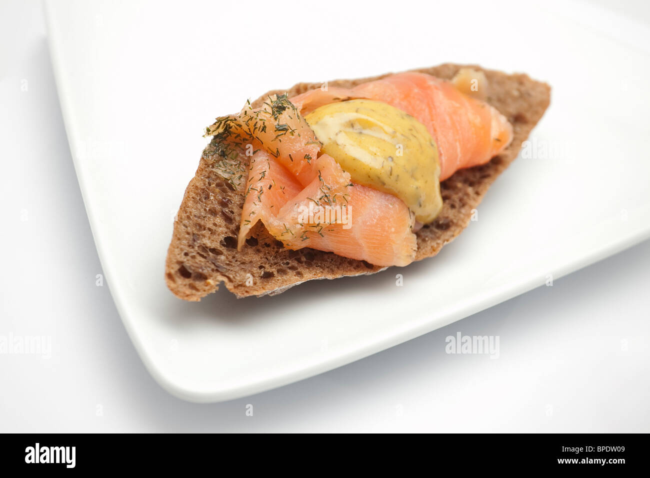 Pane di Pumpernickel con salmone affumicato e salsa di Dill alla senape Foto Stock