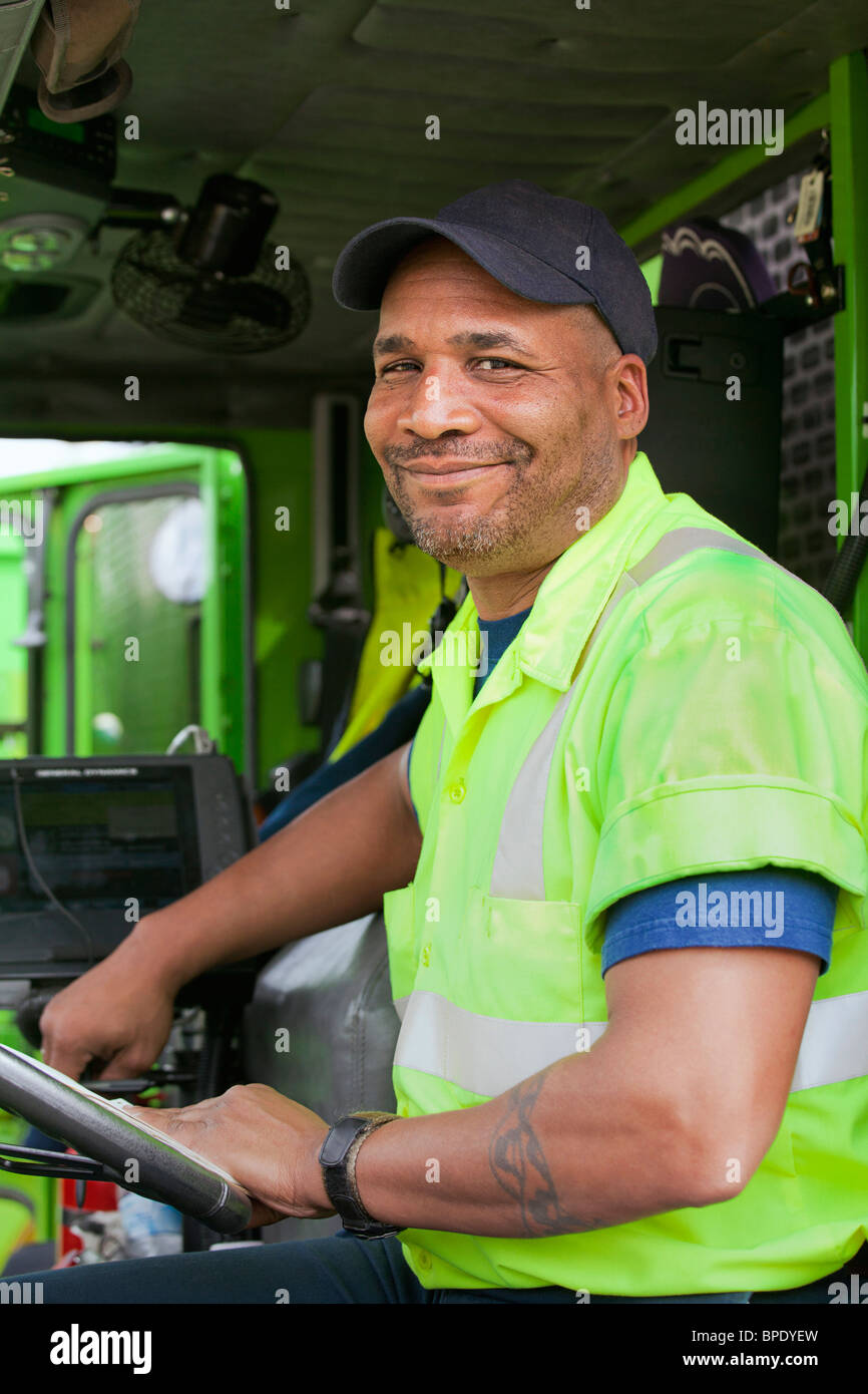 African American uomo alla guida di camion della spazzatura Foto Stock
