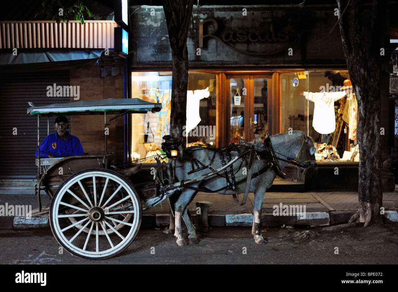Cavallo e driver di carrello in attesa di notte per i clienti Kuta Bali Foto Stock