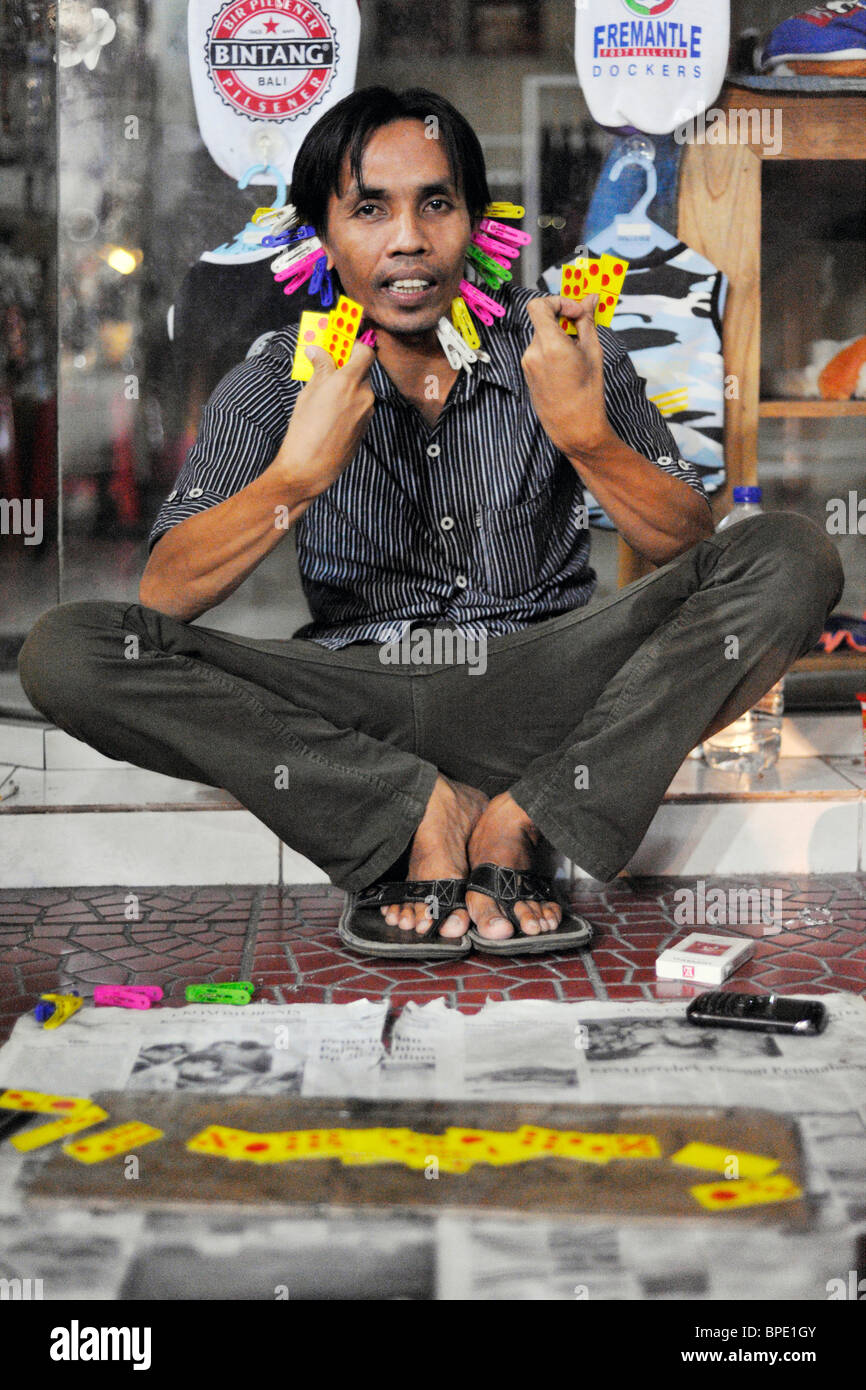 Uomo locale con spine sulla faccia come un incamerata durante la notte il gioco d'azzardo gioco Kuta Bali Foto Stock