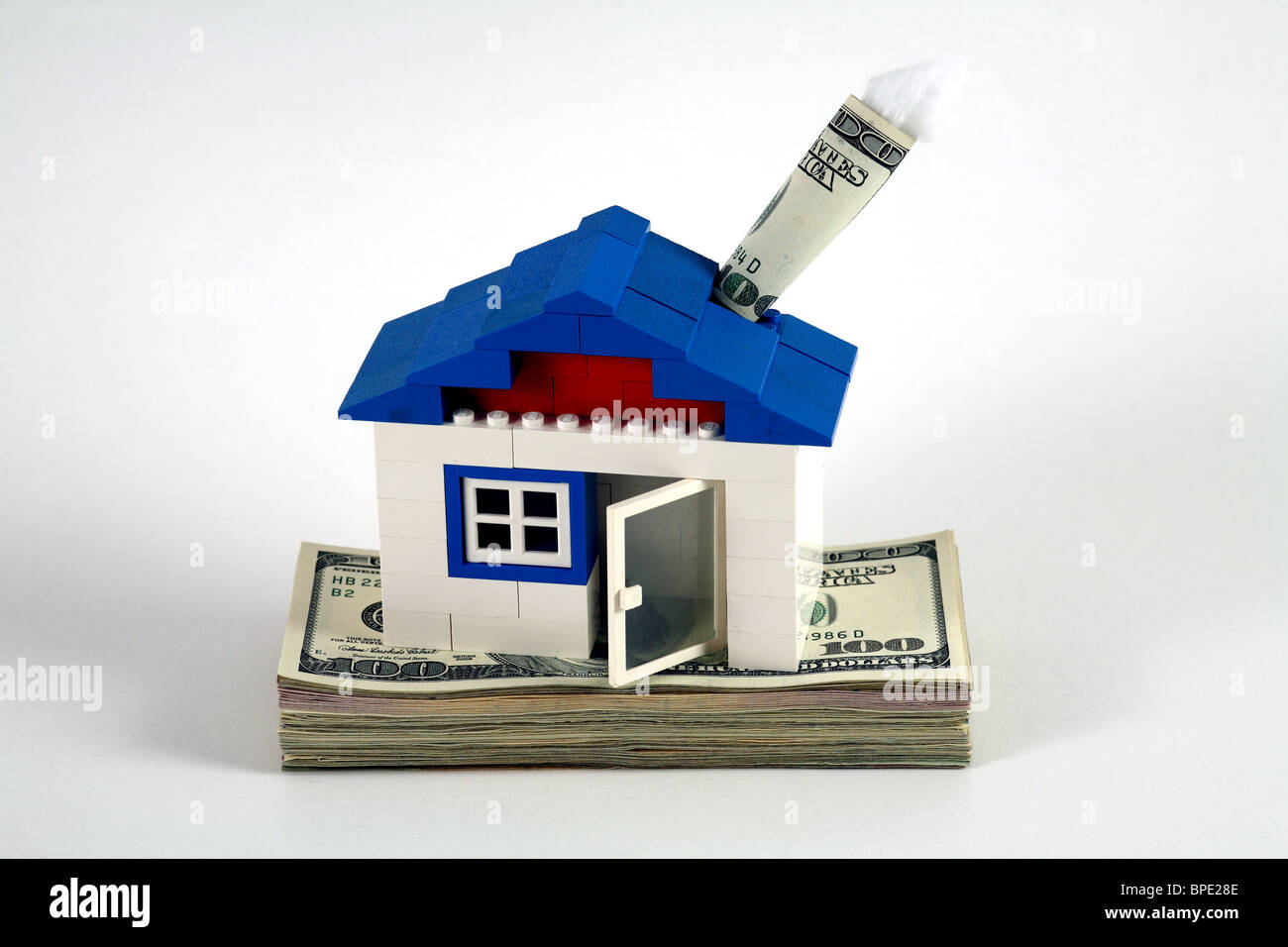 Una casa costruita dei mattoncini LEGO con un camino di 100-dollaro come simbolo del risparmio Foto Stock