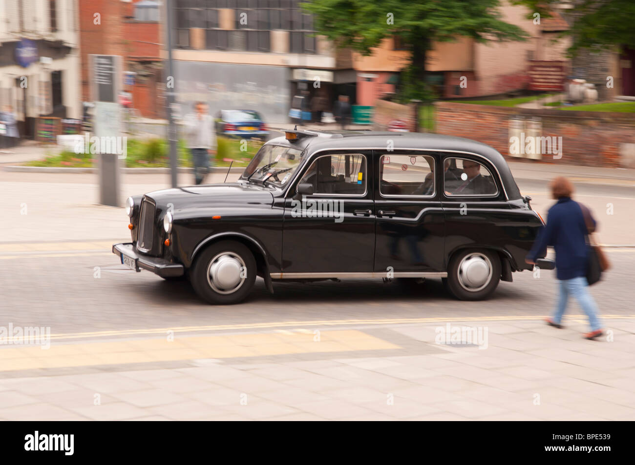 Un nero Londra Taxi guida attraverso la città che mostra il movimento in Norwich , Norfolk , in Inghilterra , Gran Bretagna , Regno Unito Foto Stock