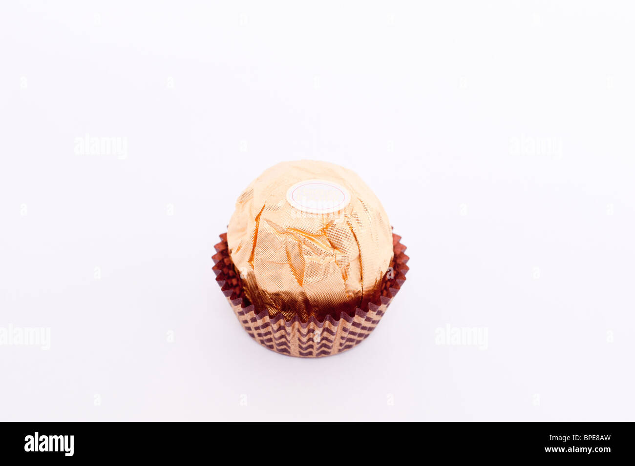 Una chiusura spaccato di un Ferrero Rocher cioccolato su sfondo bianco Foto Stock