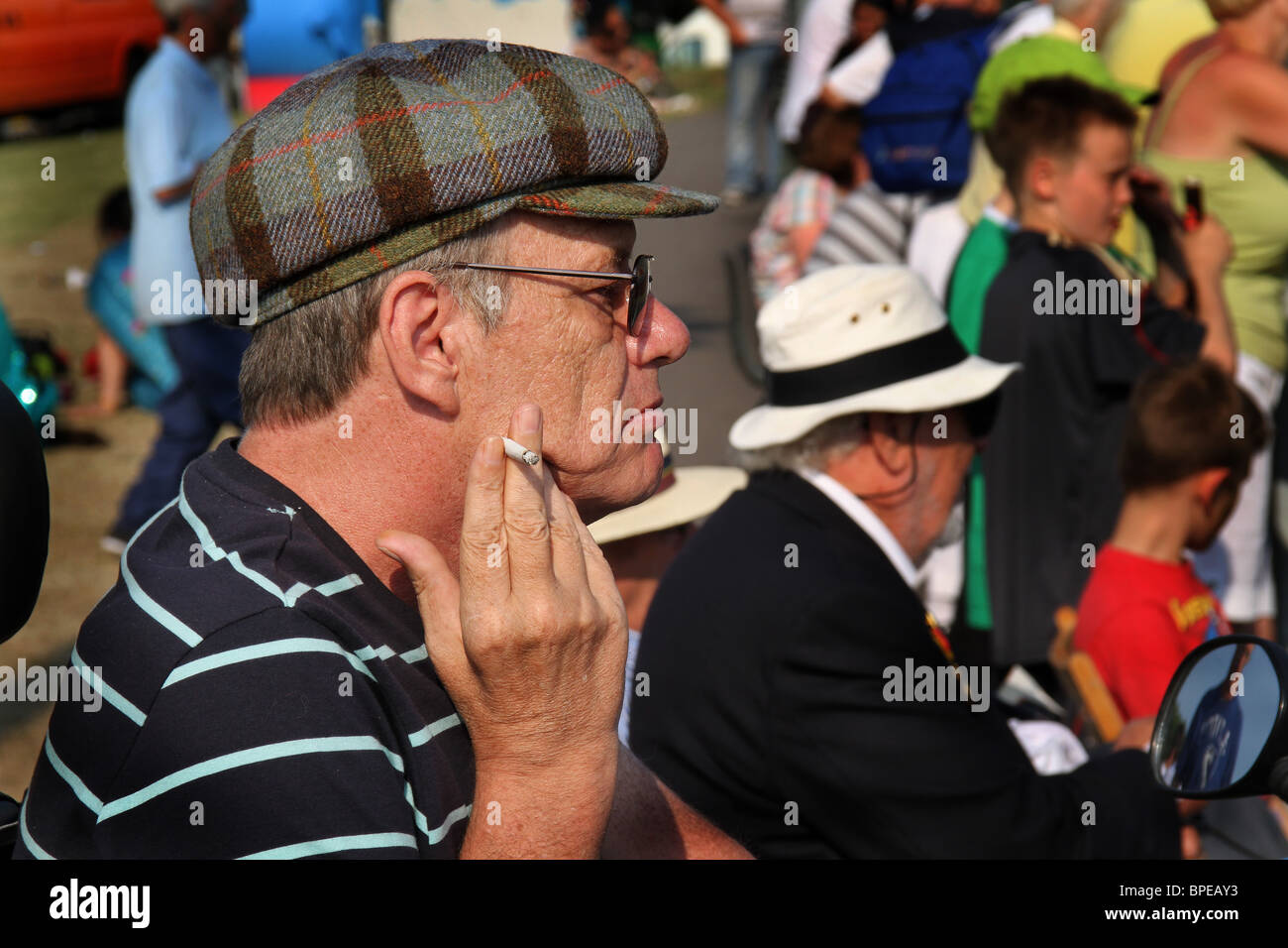 Uomo con tappo piatto e sigaretta. Foto Stock