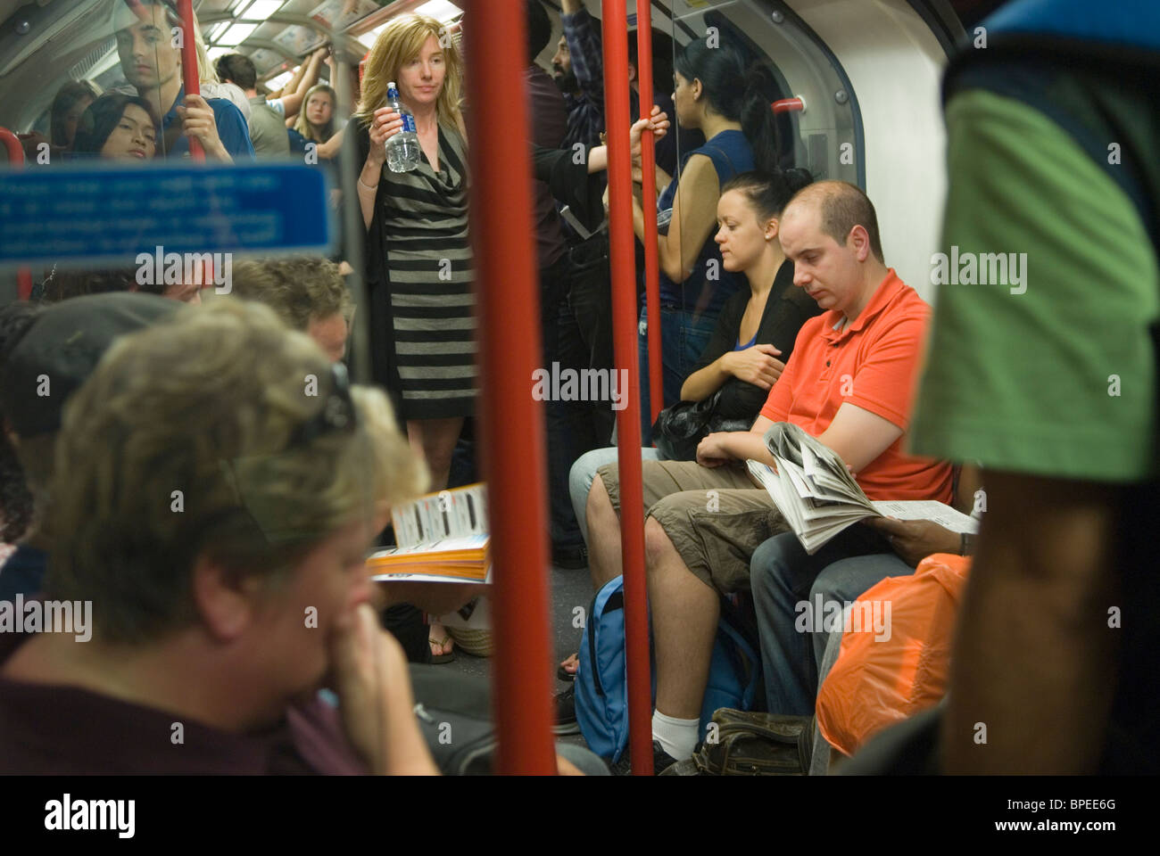 Affollata metropolitana di Londra persone passeggeri turisti che viaggiano in metropolitana. Gente stanca, donna stanca e stanca con bottiglia d'acqua Inghilterra anni '2010 2010 UK HOMER SYKES Foto Stock