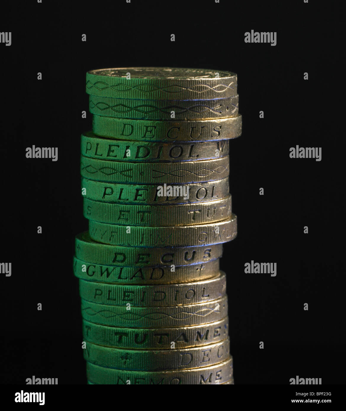Pila di Lira sterlina monete con il verde della luce riflessa Foto Stock