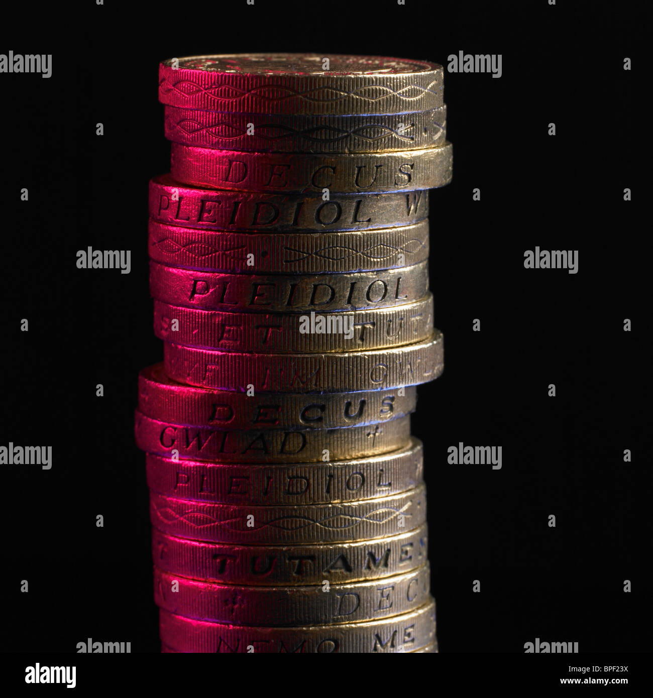 Pila di Lira sterlina monete con il rosso della luce riflessa Foto Stock