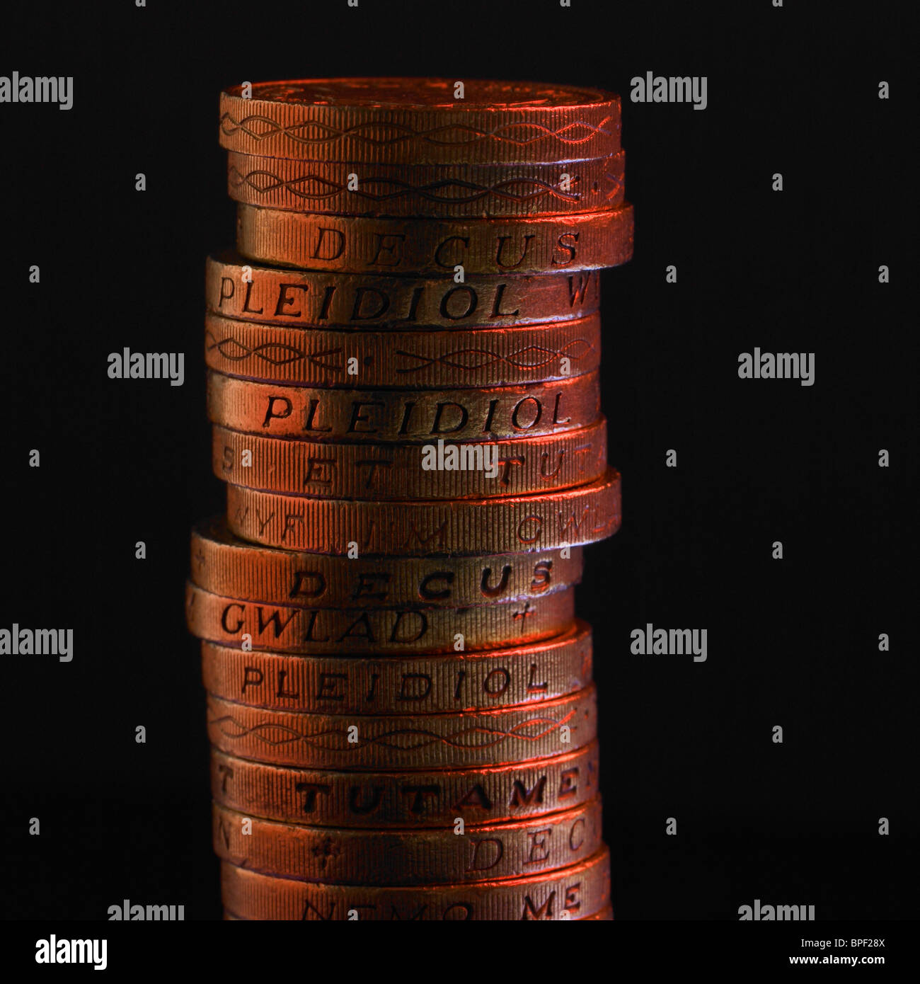 Pila di Lira sterlina monete con il rosso della luce riflessa Foto Stock