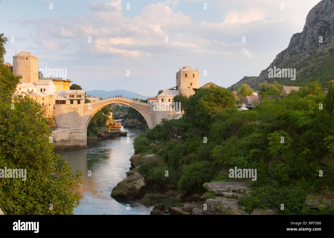 Vista lungo il fiume del vecchio ponte ricostruito. Tramonto nel tardo pomeriggio la luce. Storica città di Mostar. Foto Stock