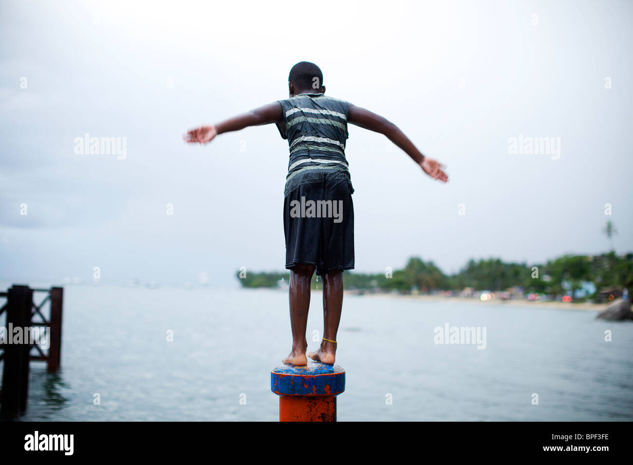 Ragazzo sul tubo intorno a saltare in acqua Foto Stock