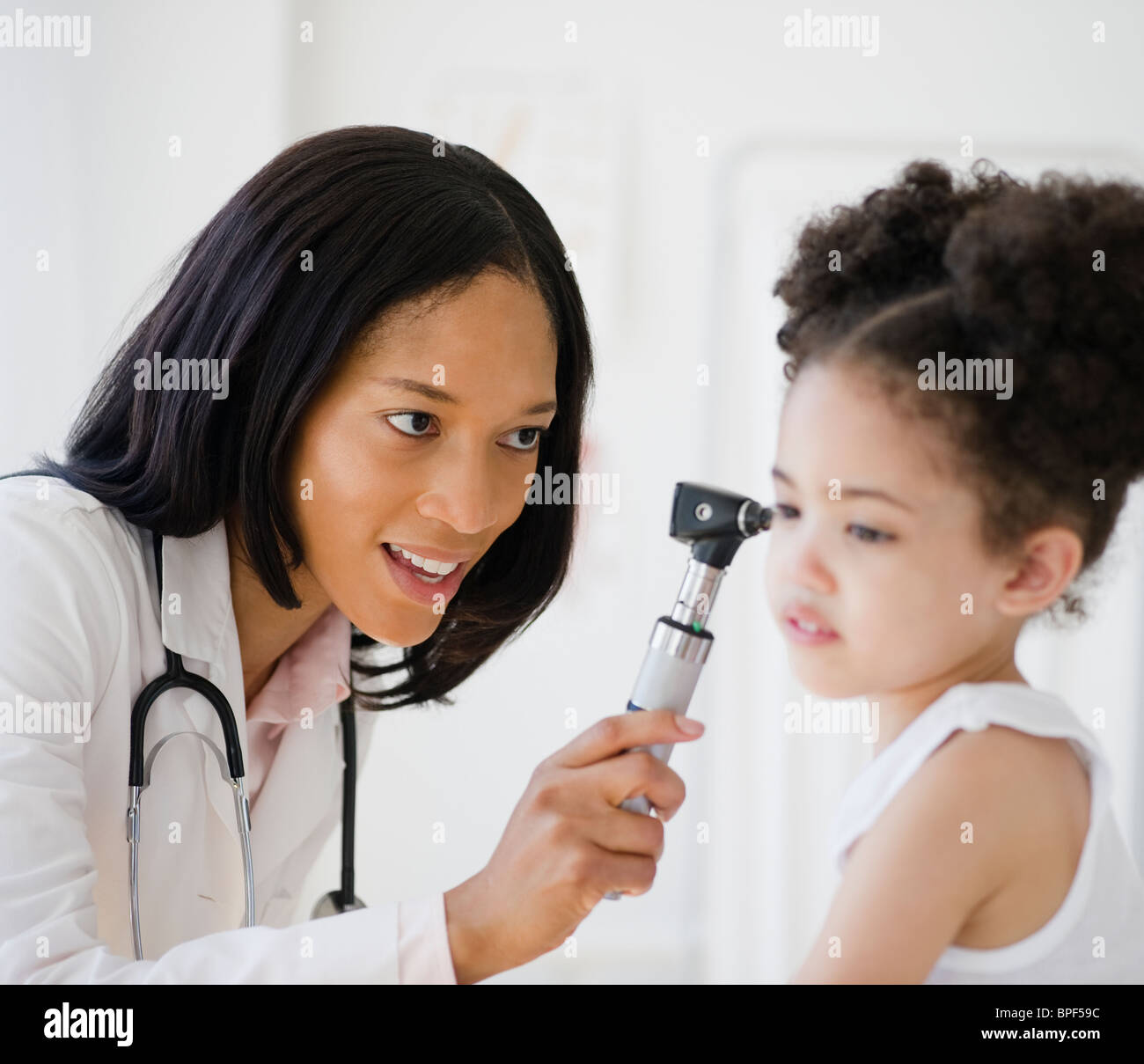 Pediatra con otoscopio esame paziente Foto Stock
