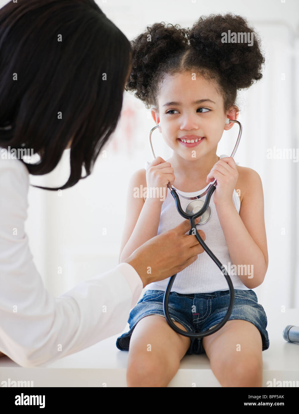 Pediatra aiutare il paziente ascolto di heartbeat Foto Stock