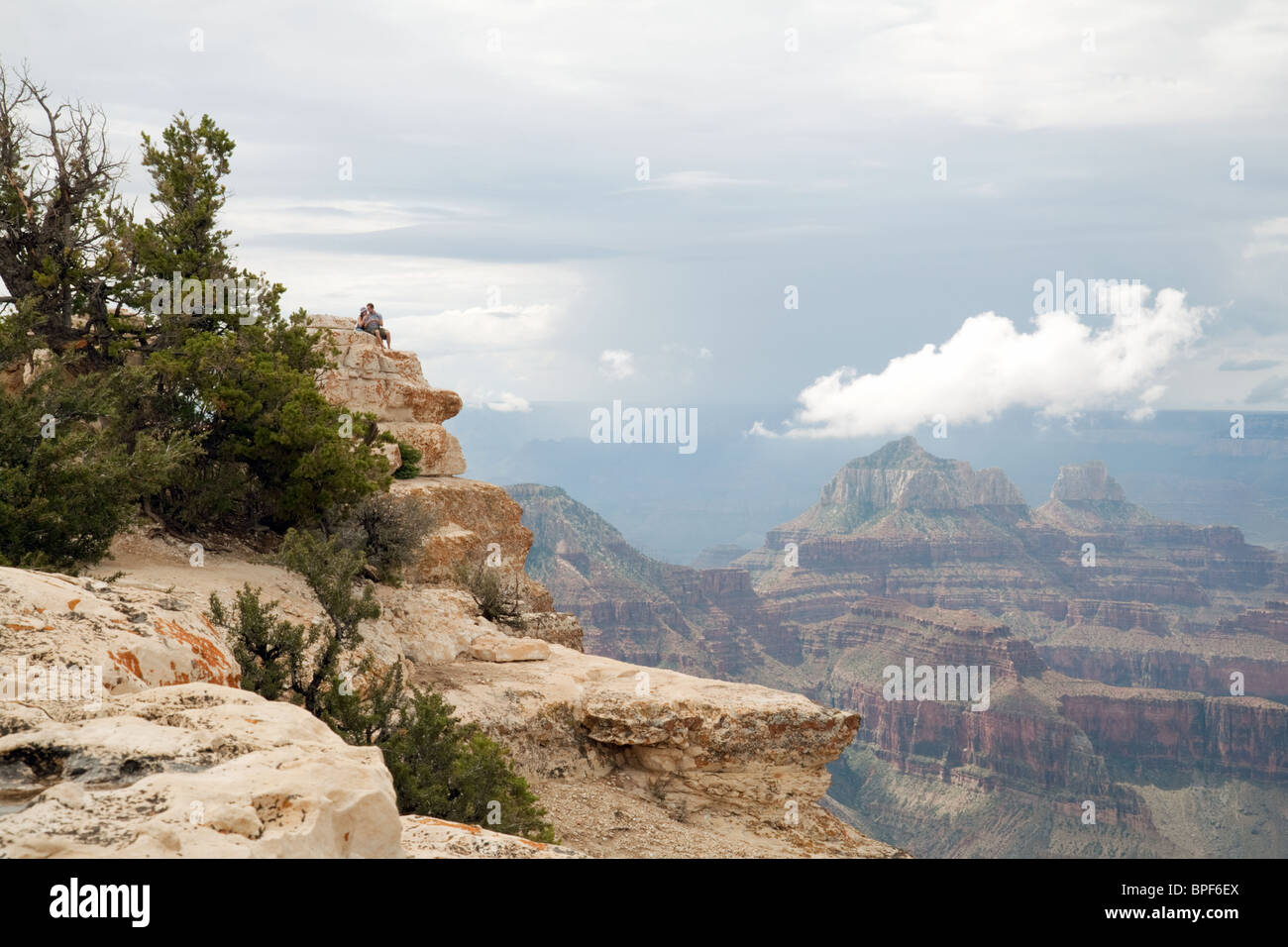 Un giovane seduto guardando il Grand Canyon da Bright Angel Point, North Rim, Arizona USA Foto Stock