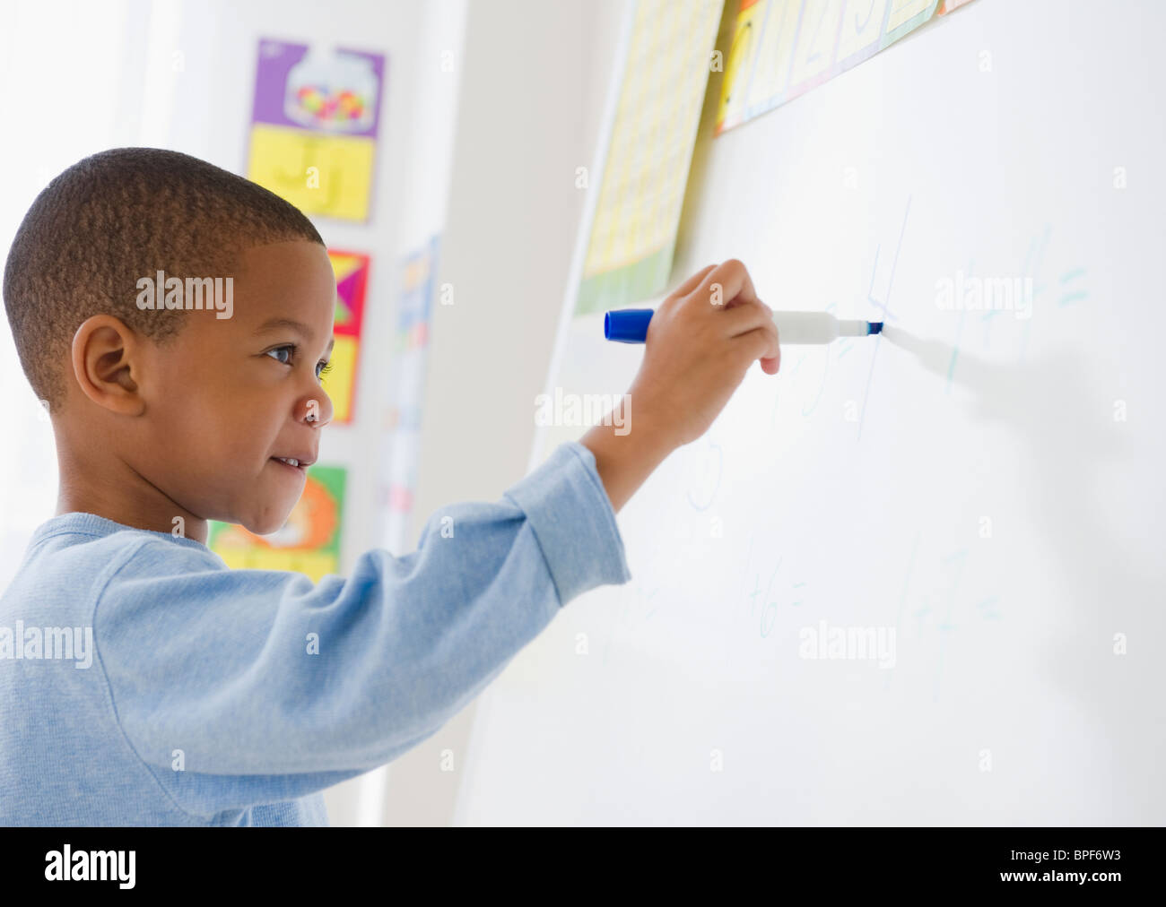 African American boy scrivendo su una lavagna bianca Foto Stock