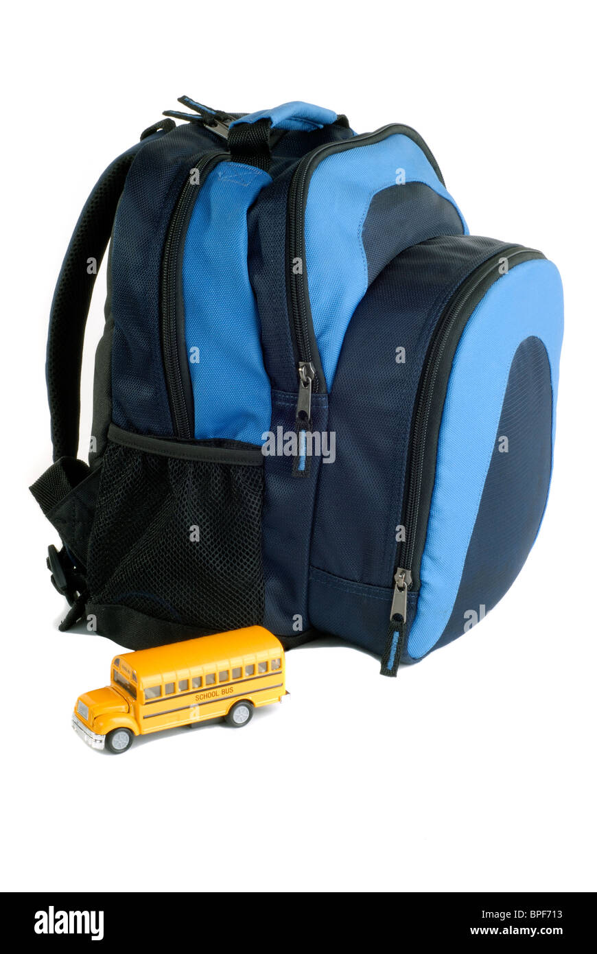 Zaino Blu con il modello pressofuso scuola giallo Bus, isolato su uno sfondo bianco Foto Stock
