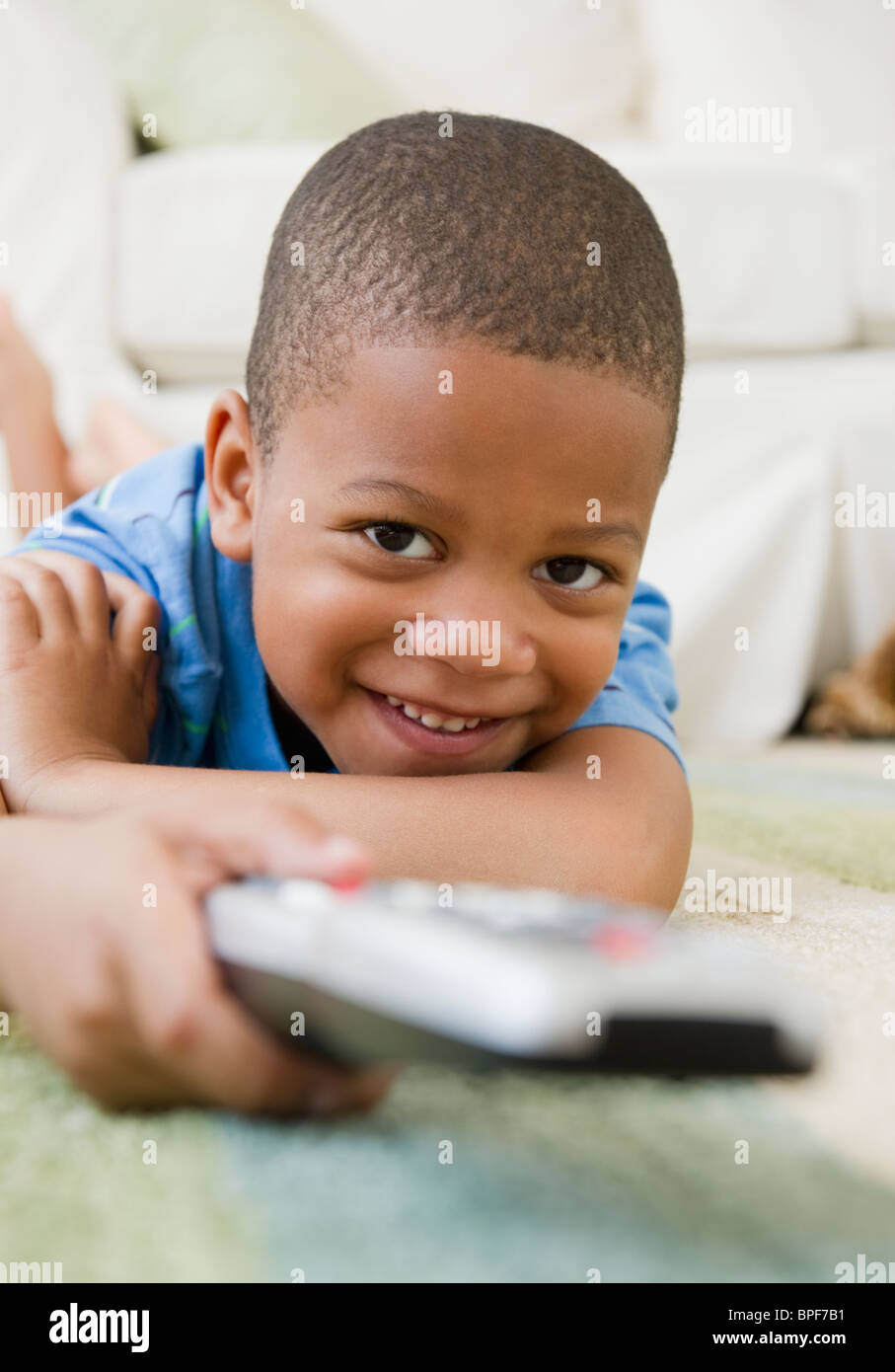African American boy posa su pavimento di guardare la televisione Foto Stock