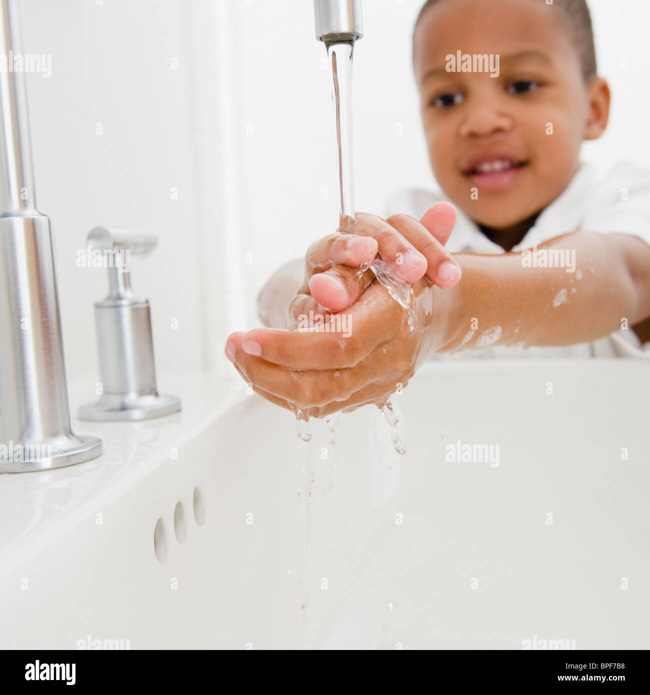 African American boy il lavaggio mani Foto Stock