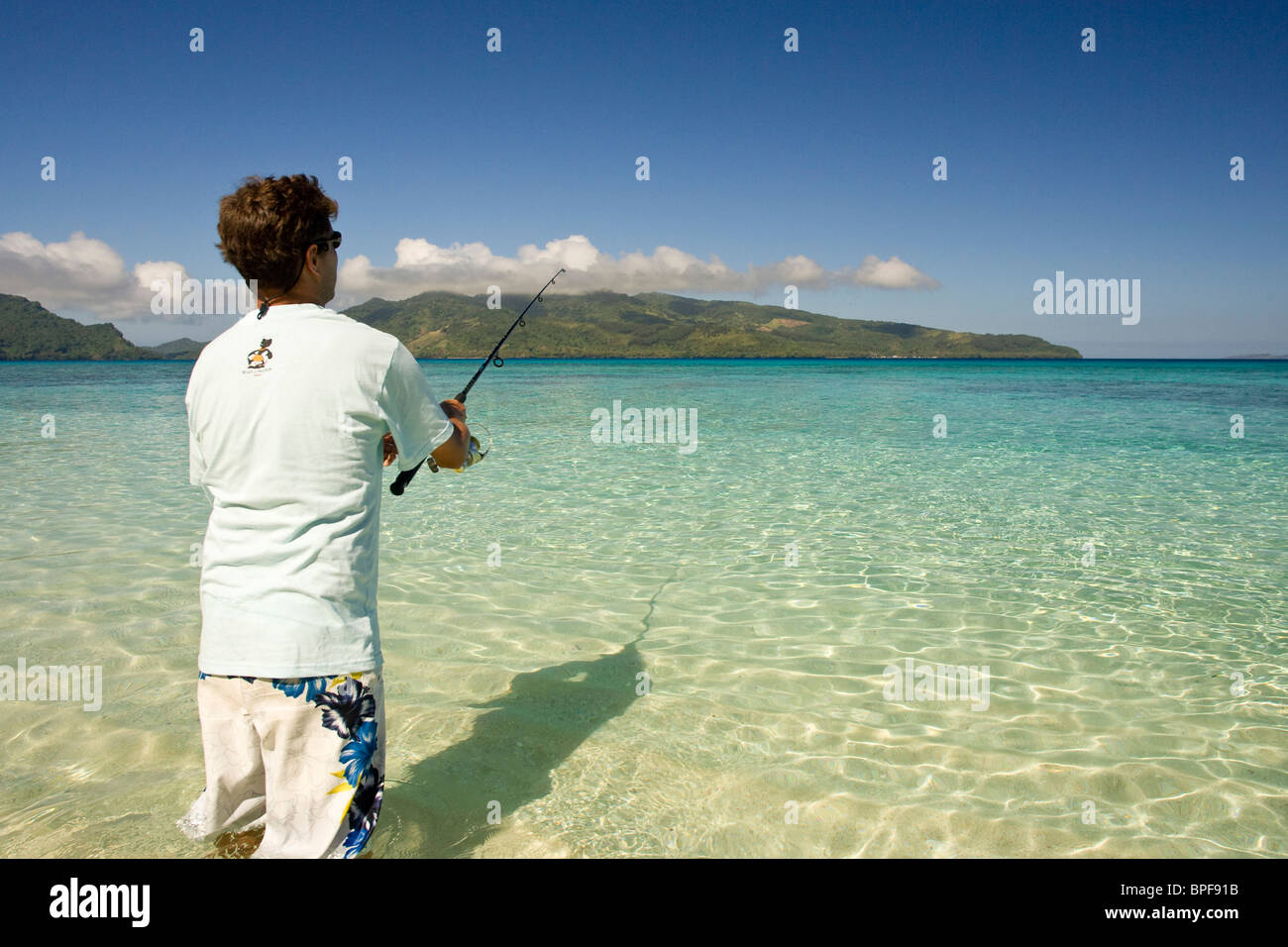 Man (età 25) fising sulla bellissima isola tropicale (Storm Island) vicino alla Laguna di Beqa, Beqa Island, Isole Figi Foto Stock