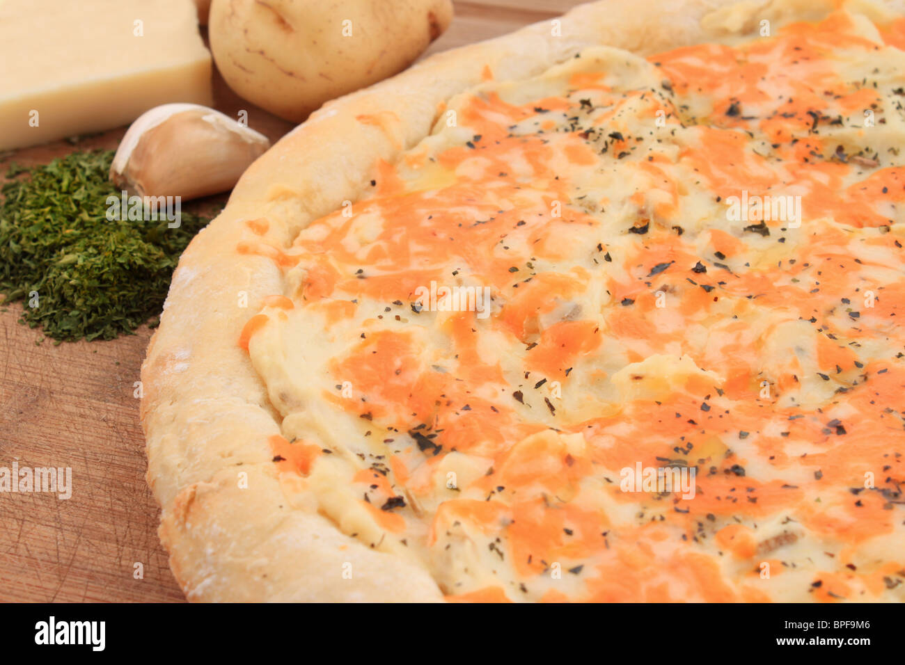 Gourmet pizza fatta con pasta fresca, patate, formaggio e aglio con il condimento Foto Stock