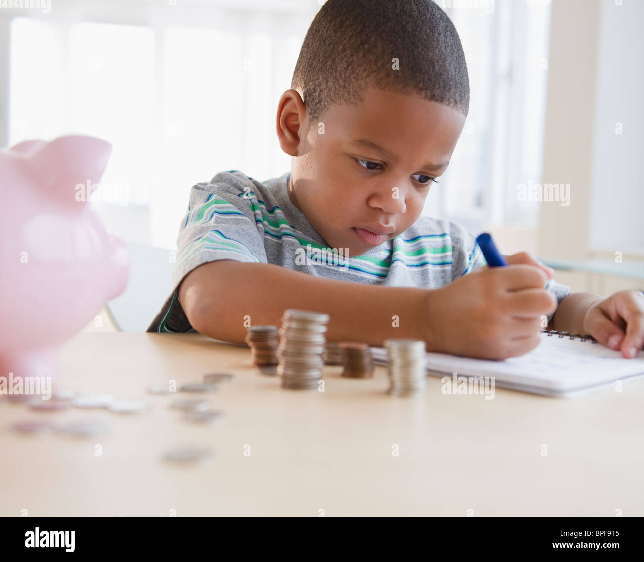 African American boy il conteggio delle monete in euro Foto Stock