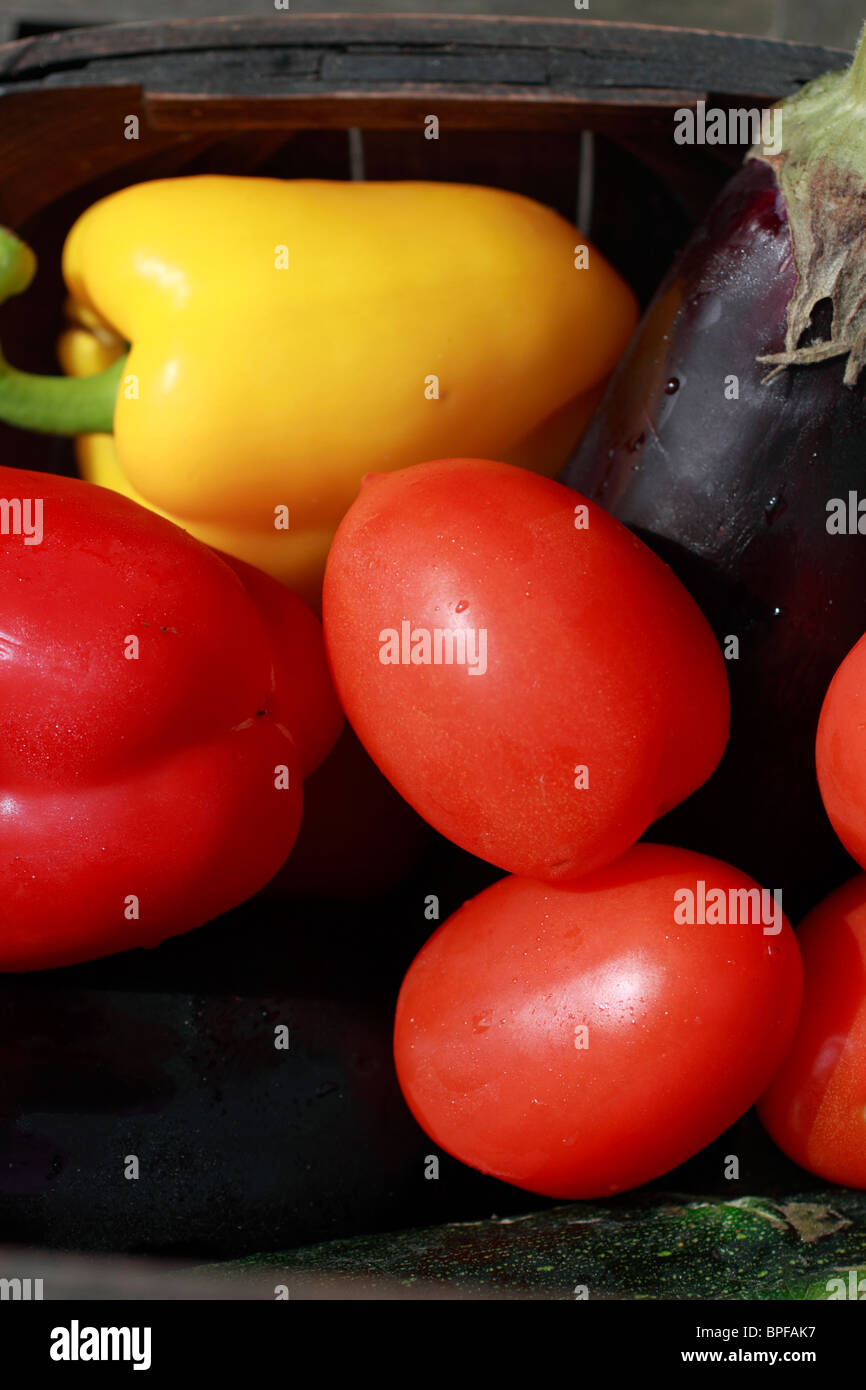 Verdure fresche per la realizzazione di una ratatouille, stufato di vegetali. Pomodori, aglio, cipolle e zucchine (zucchine), melanzana (melanzane, peperoni (poivron), carota, maggiorana e basilico Foto Stock