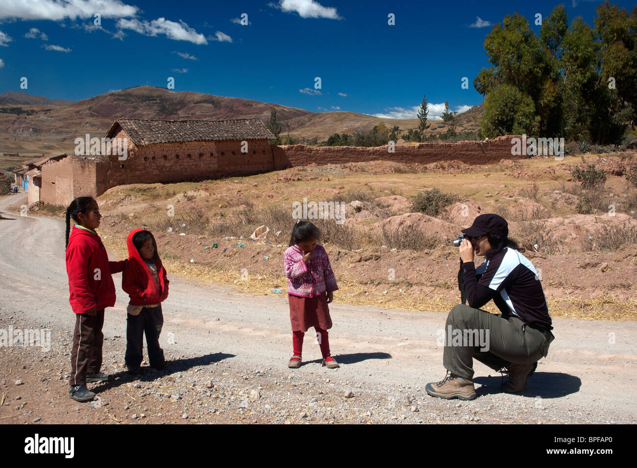 Un turista fotografie di tre piccoli bambini nei pressi di un villaggio,vicino Urubamba nella Valle Sacra, Perù. Foto Stock