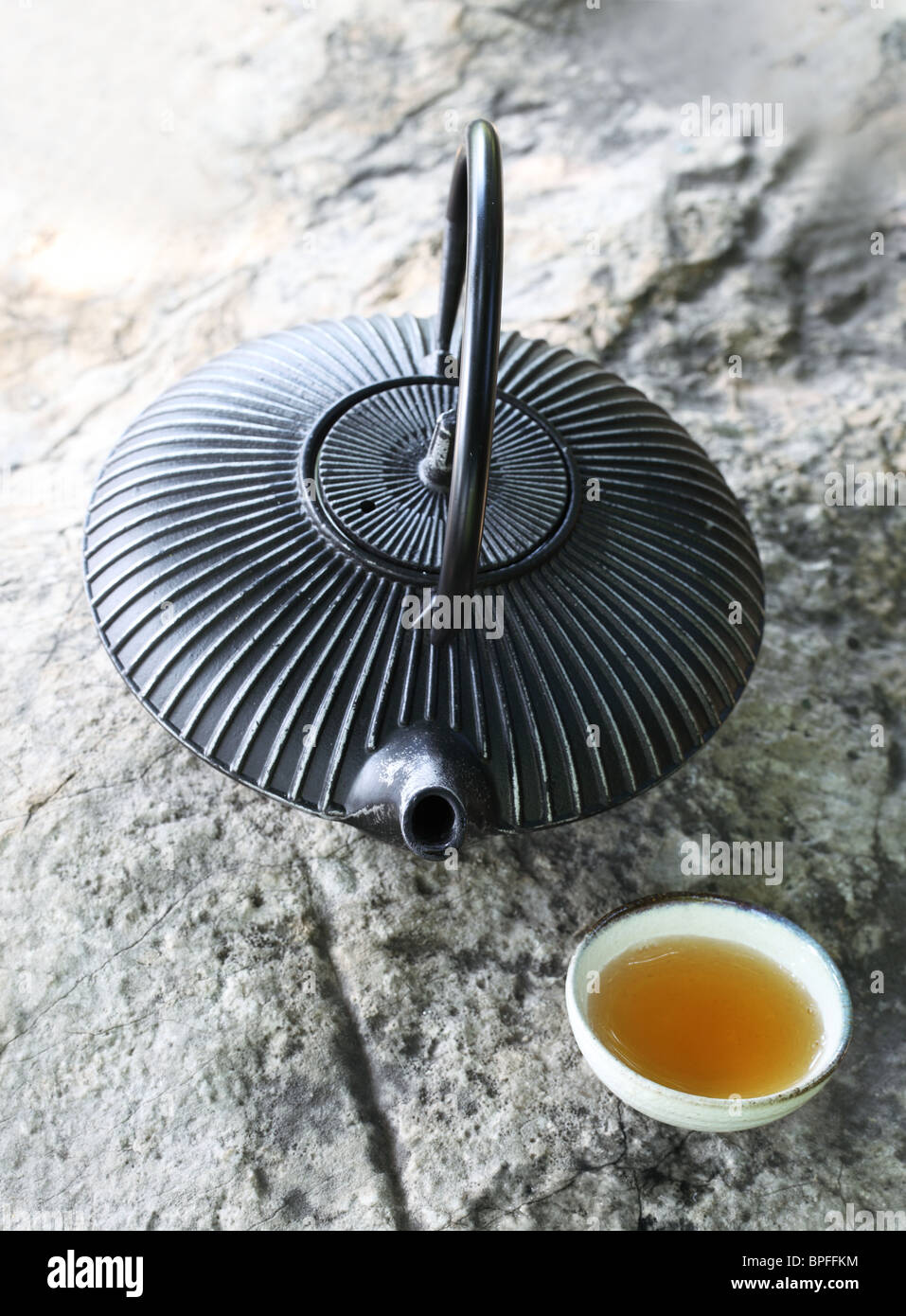 Ferro nero asian teiera con tazza di tè su roccia,Closeup. Foto Stock