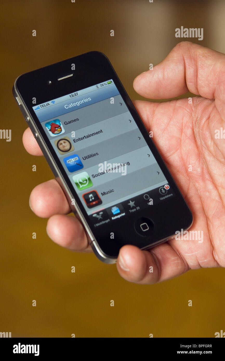 IPhone 4 nel palmo di una mano, che mostra le app store. Foto Stock