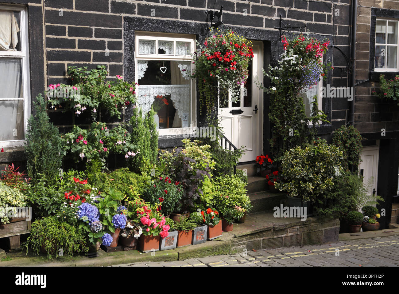 Villetta a schiera con display floreali, Haworth, West Yorkshire, Inghilterra, Regno Unito Foto Stock