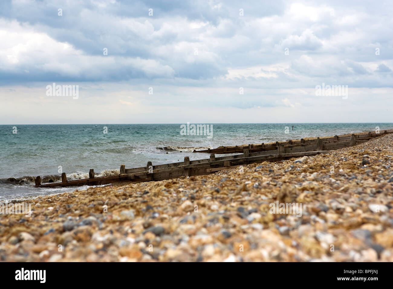 Groynes su ghiaia spiaggia paesaggio Foto Stock