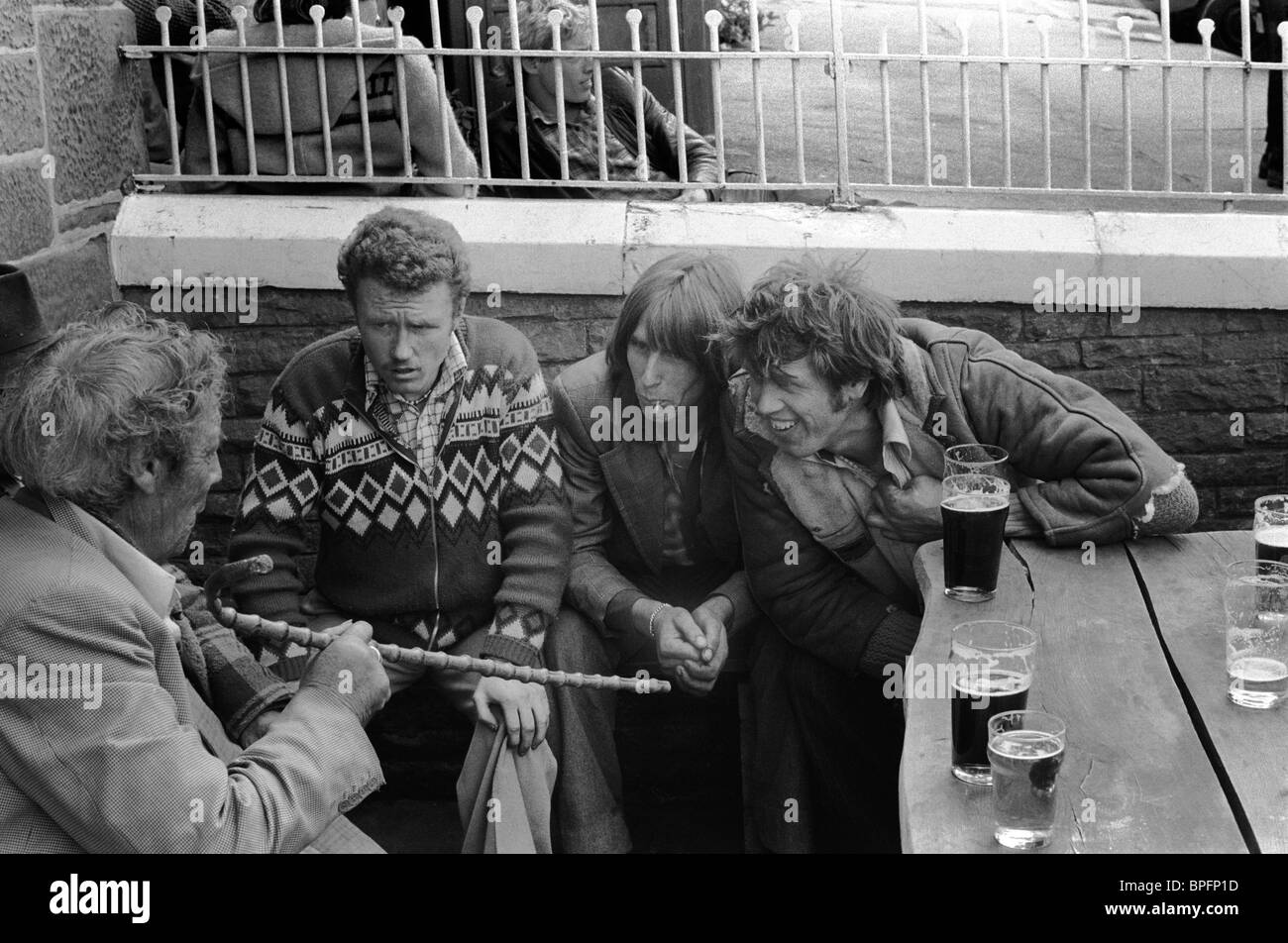 Raccontare storie. Un uomo zingaro anziano che racconta una storia alta a tre zingari più giovani con una pinta di due seduti fuori da un pub Appleby. Appleby Gypsy Horse Fair 1981. 1980S UK HOMER SYKES Foto Stock