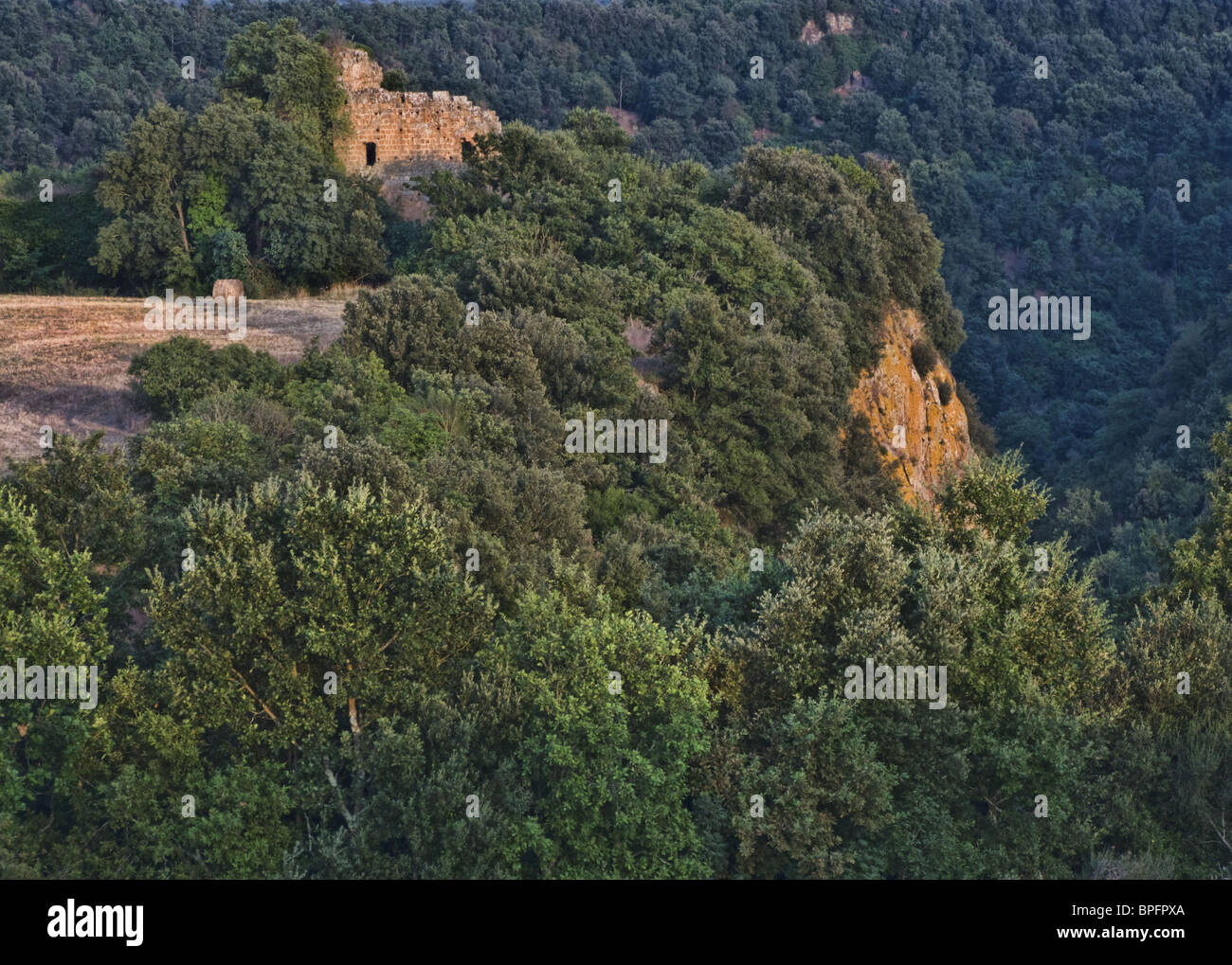 Colline boscose della Tuscia, nel nord della regione Lazio, Italia. Sullo sfondo i ruderi del castello medievale. Foto Stock