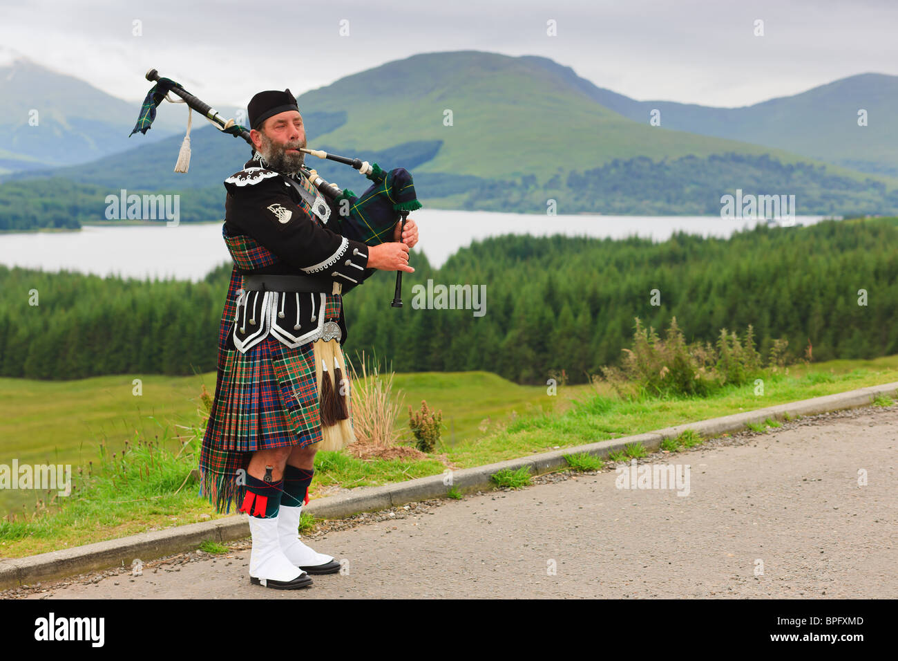 Cornamuse player sulle Highlands scozzesi Foto Stock