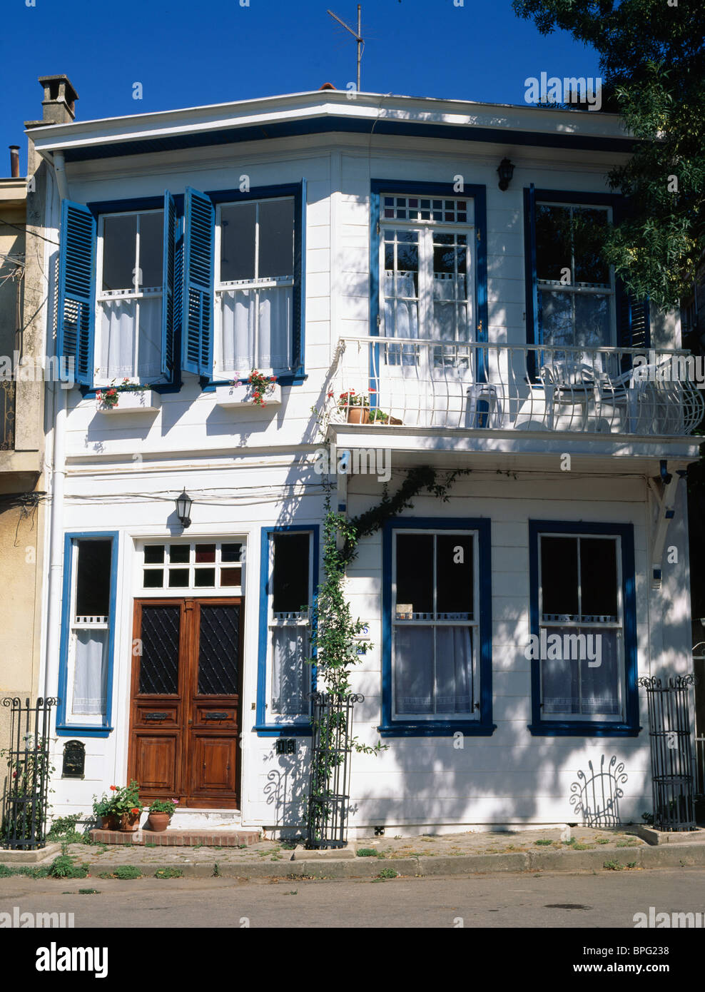 Di piccole dimensioni e di colore bianco bianco tradizionale casa Turca con persiane blu Foto Stock