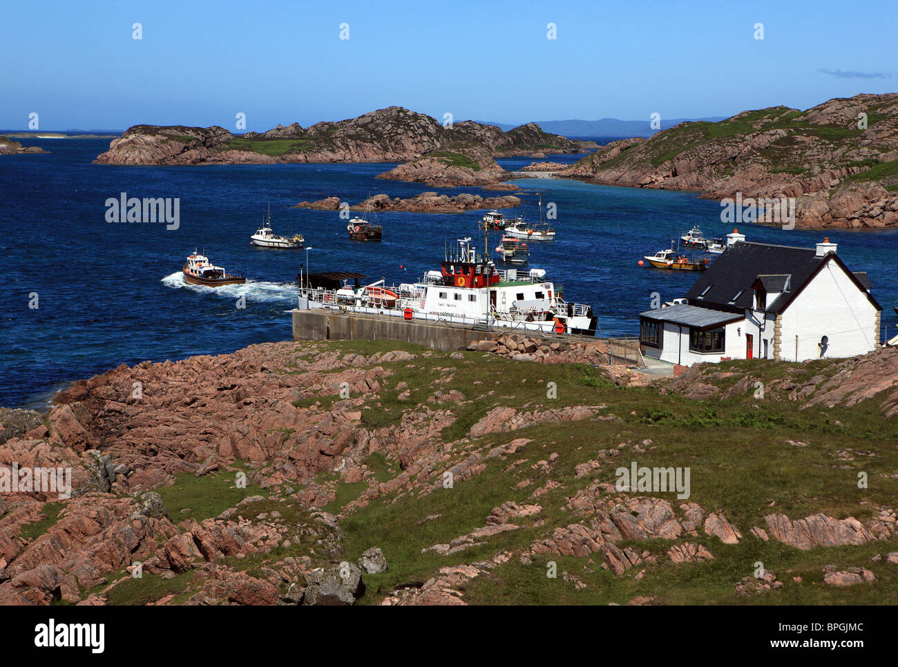 Isle of Mull town, Fionnphort, con il traghetto Calmac a scivolo e barche da pesca nella baia Foto Stock