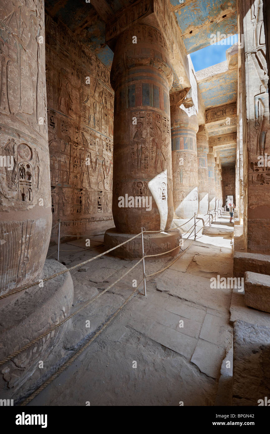 Colonne colorate e il bassorilievo di western colonnato, secondo cortile del tempio mortuario di Ramesse Medinet Habu Luxor Tebe Egitto Foto Stock