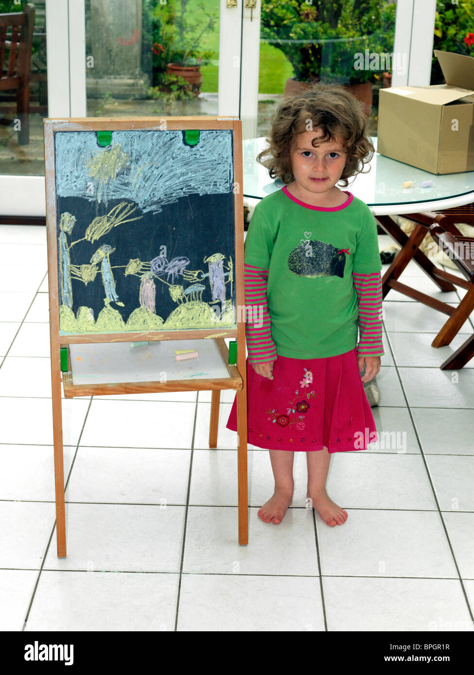 Ragazza giovane disegno con gesso sulla lavagna Foto Stock