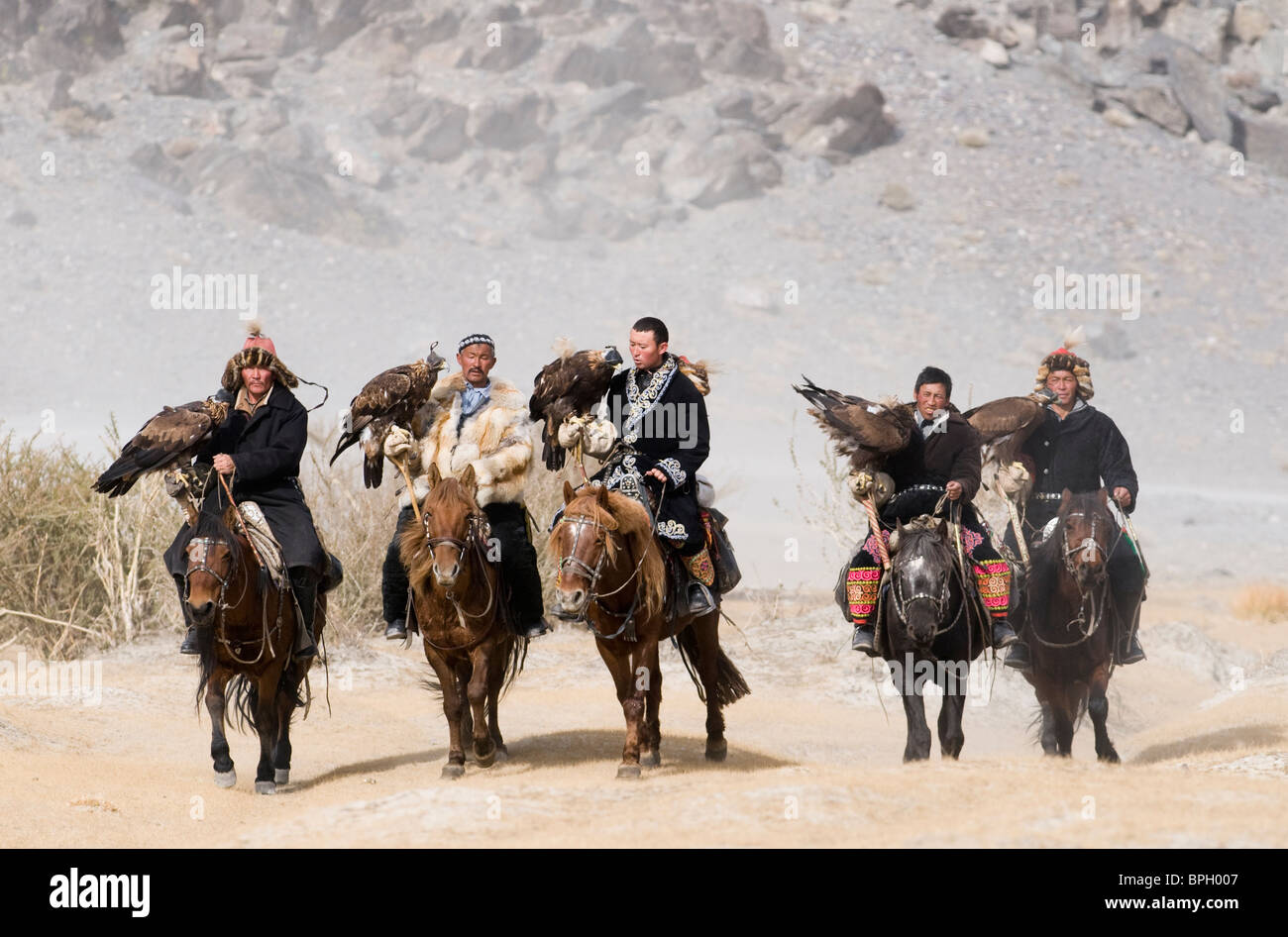 Il kazako eagle cacciatori con aquile reali sul modo per i cacciatori di Eagle Festival in Bayan-Ulgii nelle montagne di Altai Mongolia occidentale Foto Stock