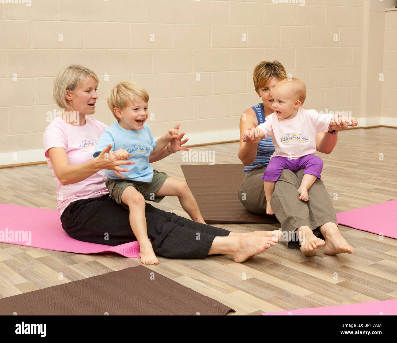 Le madri e i bambini piccoli esercizi yoga classe Foto Stock