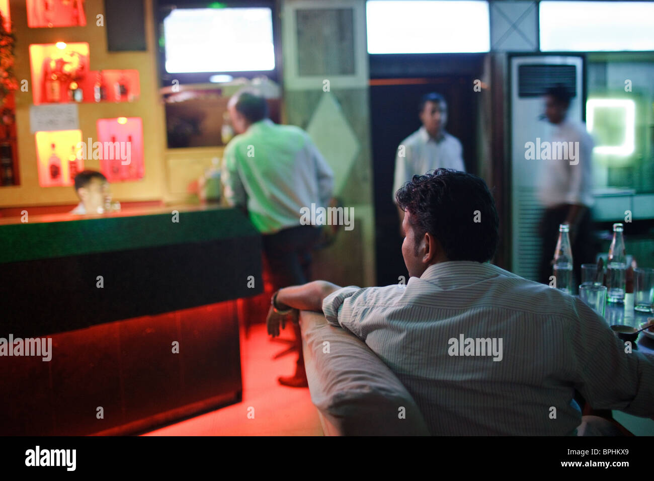Un patrono di bere alcolici in un bar locale nel centro della città di Jammu, India. Foto Stock