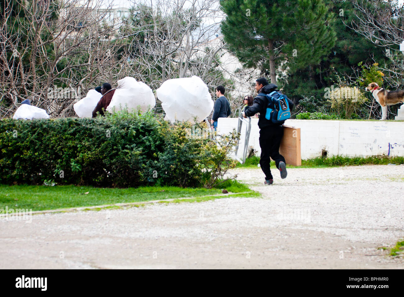 ATHENS, Grecia - 14 febbraio: gli immigrati la vendita di merci contraffatte in esecuzione dalla polizia nel centro il 14 febbraio 2010. Foto Stock