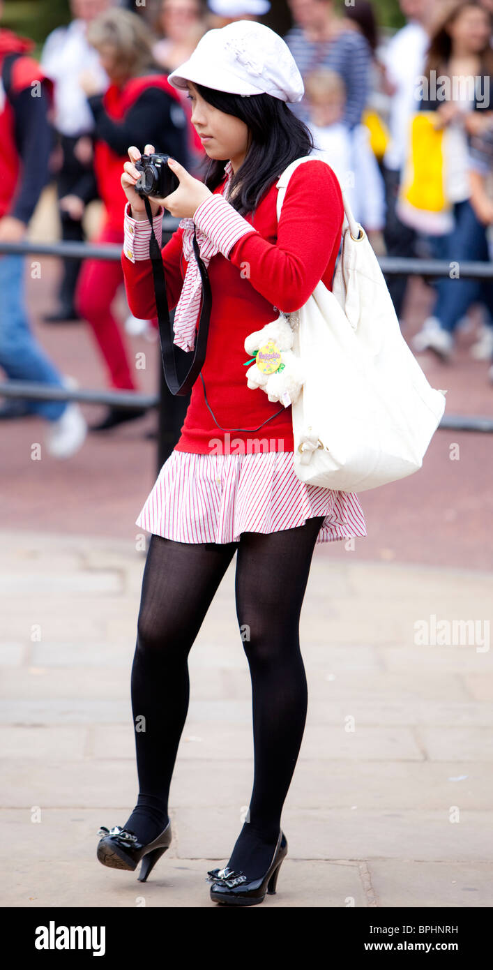 Ritratto completo di una ragazza turistica asiatica che scatta foto con fotocamera digitale, Londra, Inghilterra, Regno Unito. Foto Stock